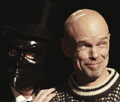 A spectator, a skull and a masked character interacting